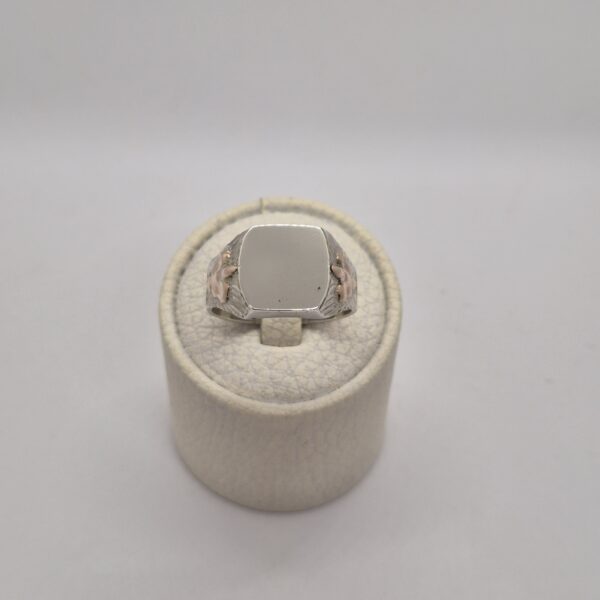 Anillo con sello, flor y letras grabadas